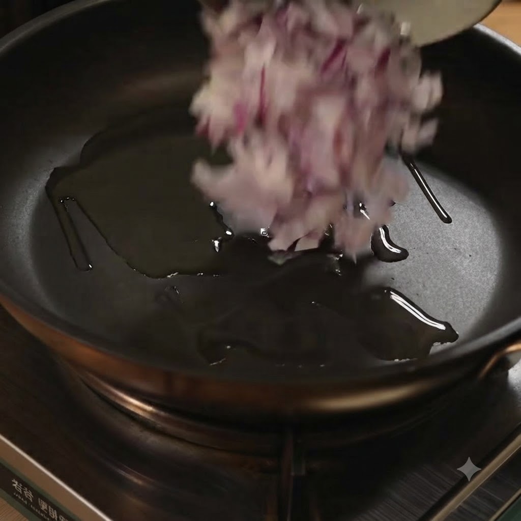 Gehackte rote Zwiebeln werden in eine Bratpfanne mit Öl gegeben.