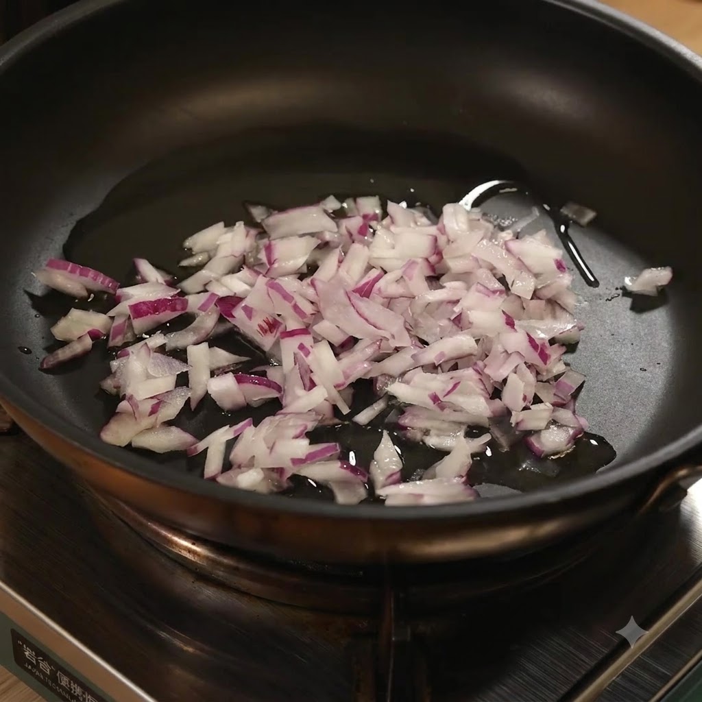 Minzierter Knoblauch wird in die Bratpfanne mit gehackten roten Zwiebeln und Öl gegeben.