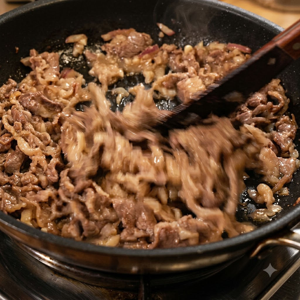 Gehackte getrocknete rote Chilischoten werden mit Rindfleisch und Zwiebeln in einer Bratpfanne angebraten.