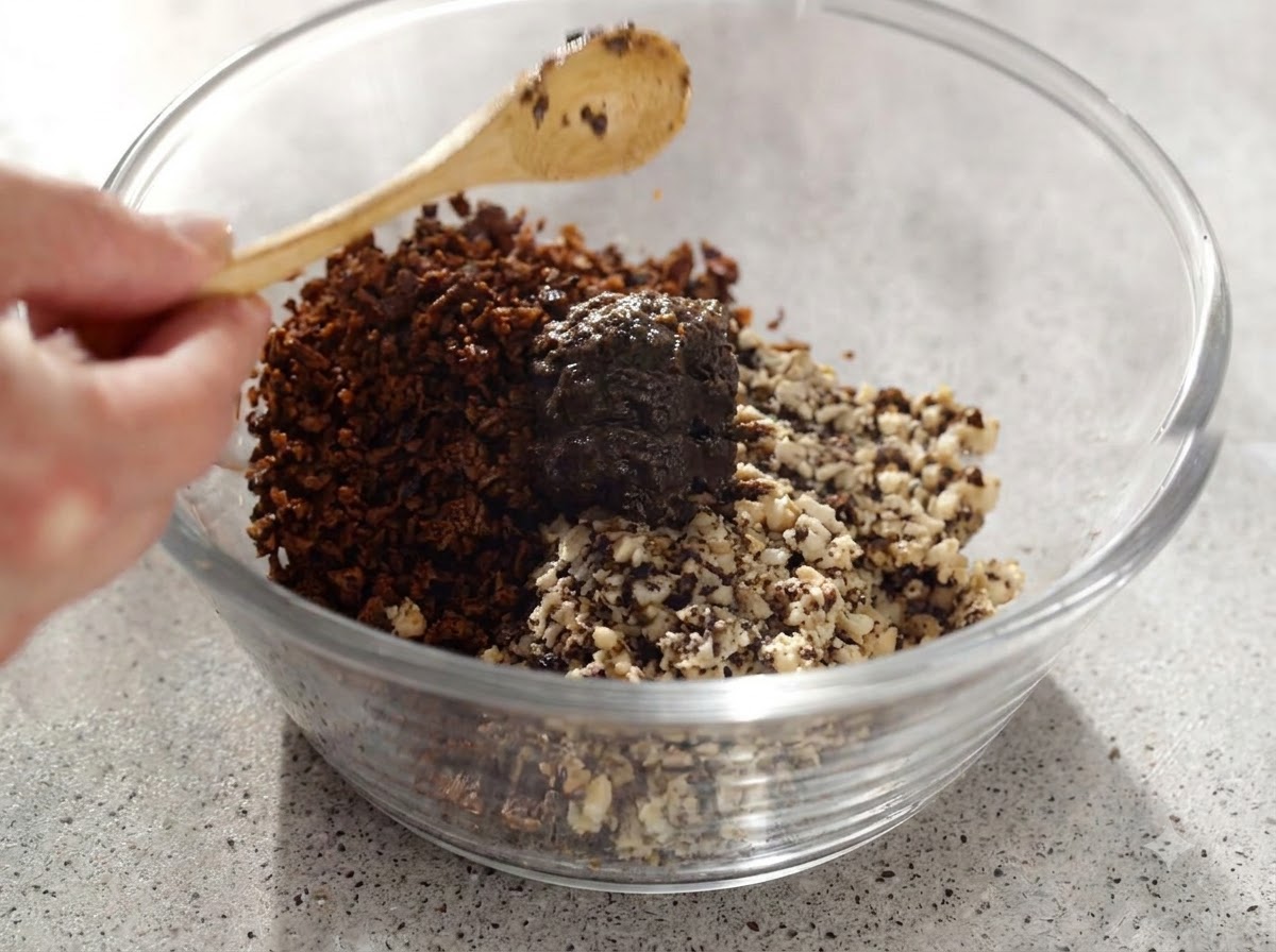 Trüffelpaste und gehackte Pilze werden mit einem Holzlöffel gründlich in einer Glasschüssel vermischt.
