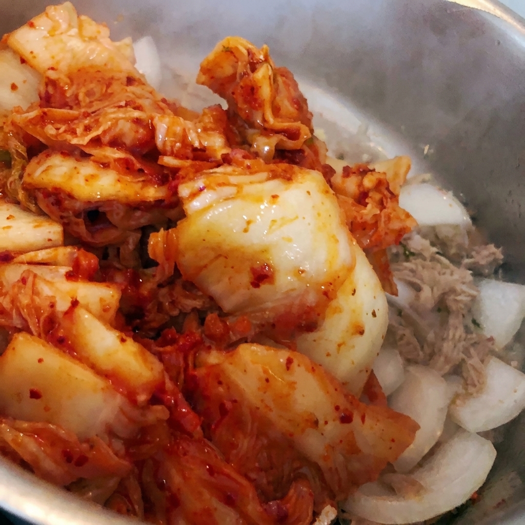Gehacktes Kimchi wird zu den bestehenden Zutaten in den Topf gegeben.
