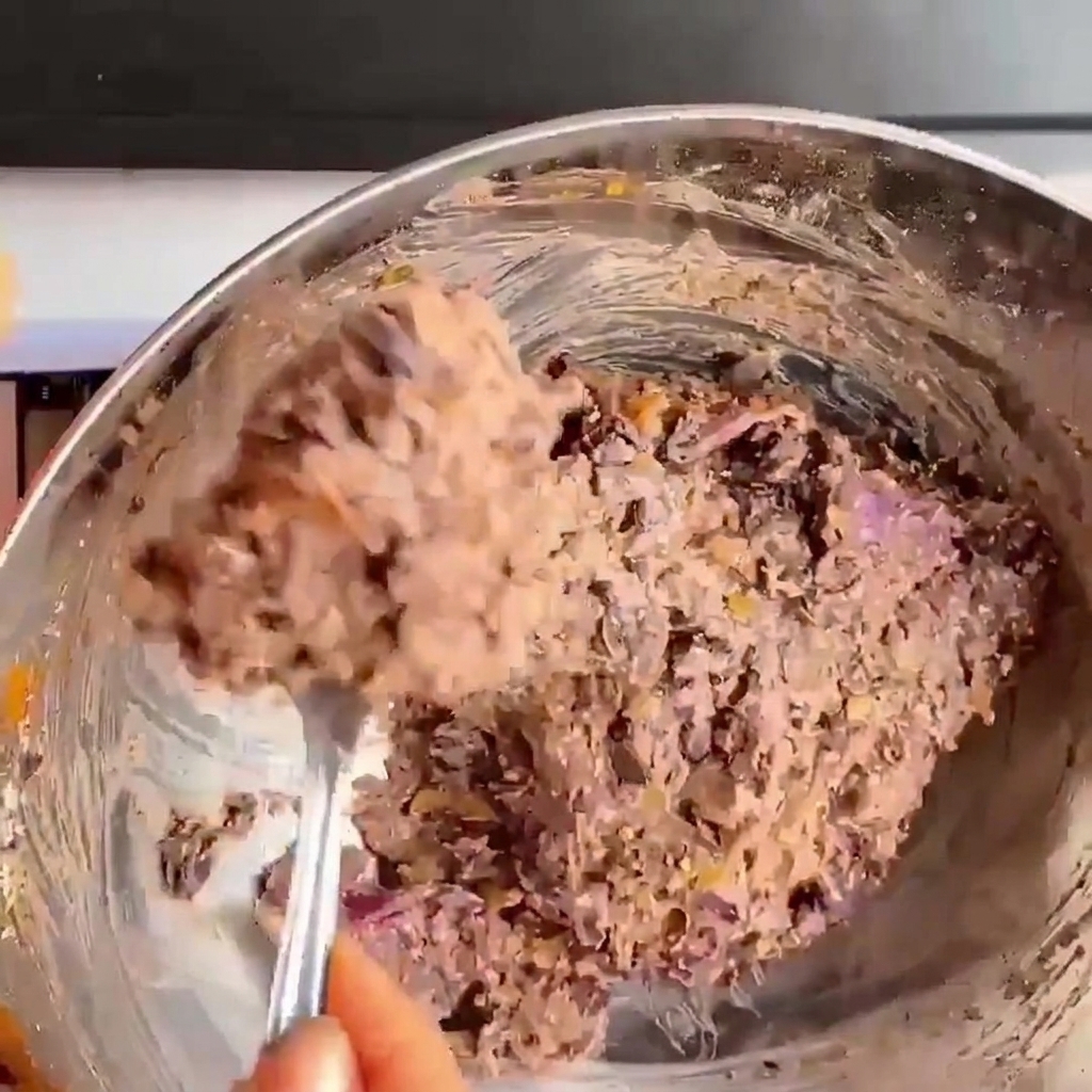Nahaufnahme von Händen, die die Schwarze-Bohnen-Mischung zu einem runden Burgerpatties drücken und formen.