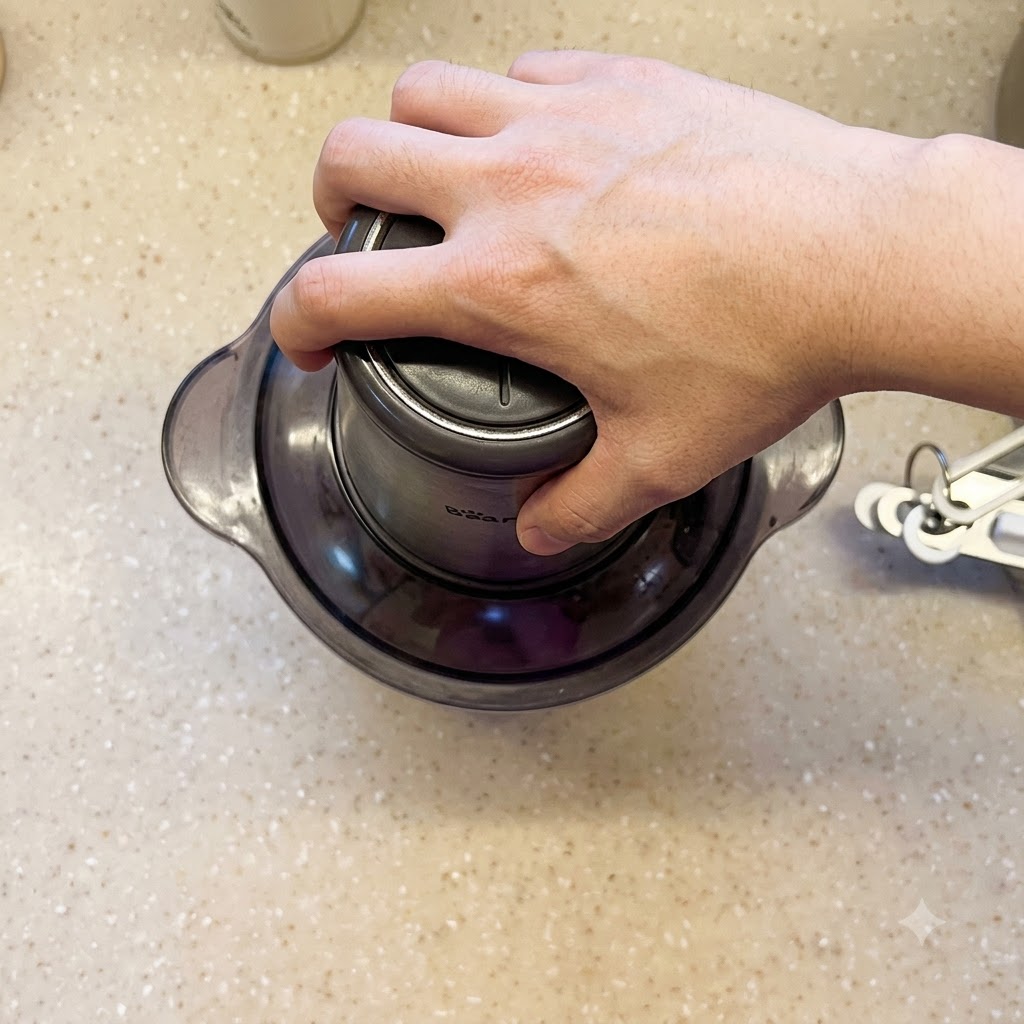 Eine Hand drückt auf den Deckel eines Mixers, um ihn für den zweiten Mixvorgang zu betätigen.