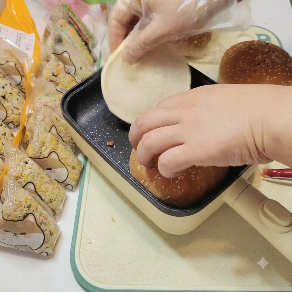 Burger-Brötchen werden sanft in einer schwarzen quadratischen Flachpfanne erwärmt.
