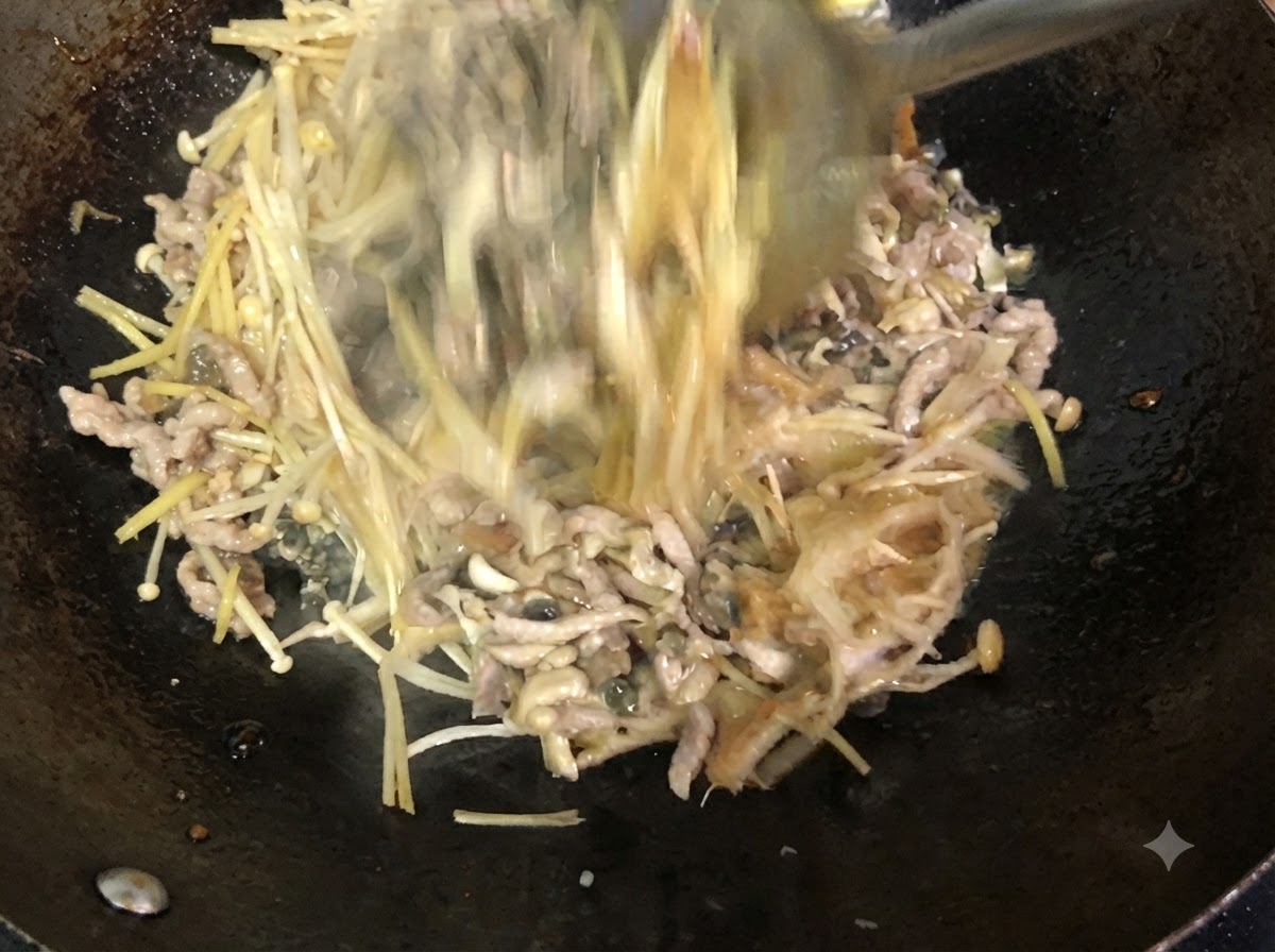 Zutaten werden mit einem Metallwender aktiv im Wok verrührt und vermischt.