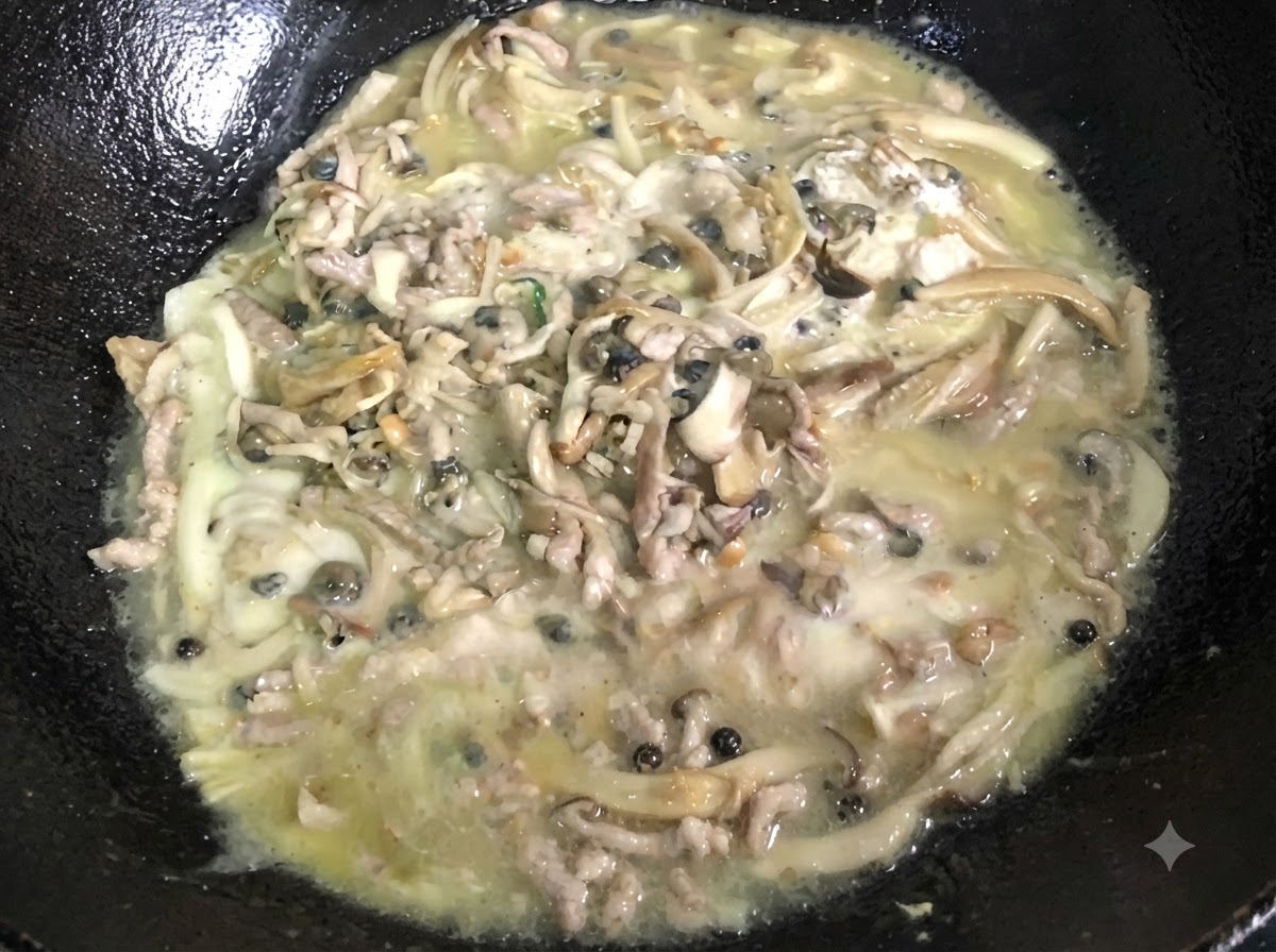Eine dicke, blubbernde Masse wird kontinuierlich in einem schwarzen Wok verrührt.