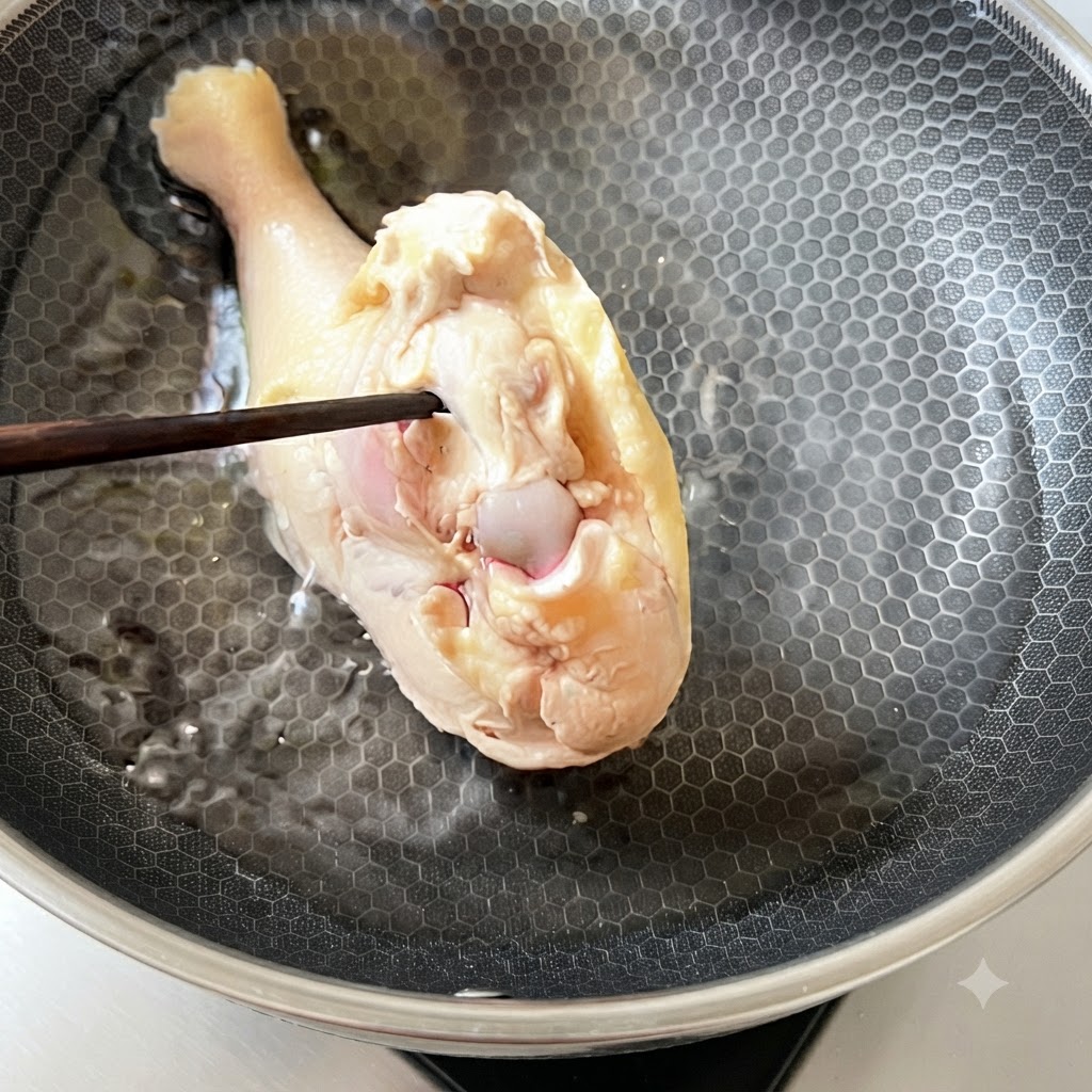 Ein blanchierter Hähnchenschenkel wird zurück in kaltes Wasser in einem Kochtopf gelegt.