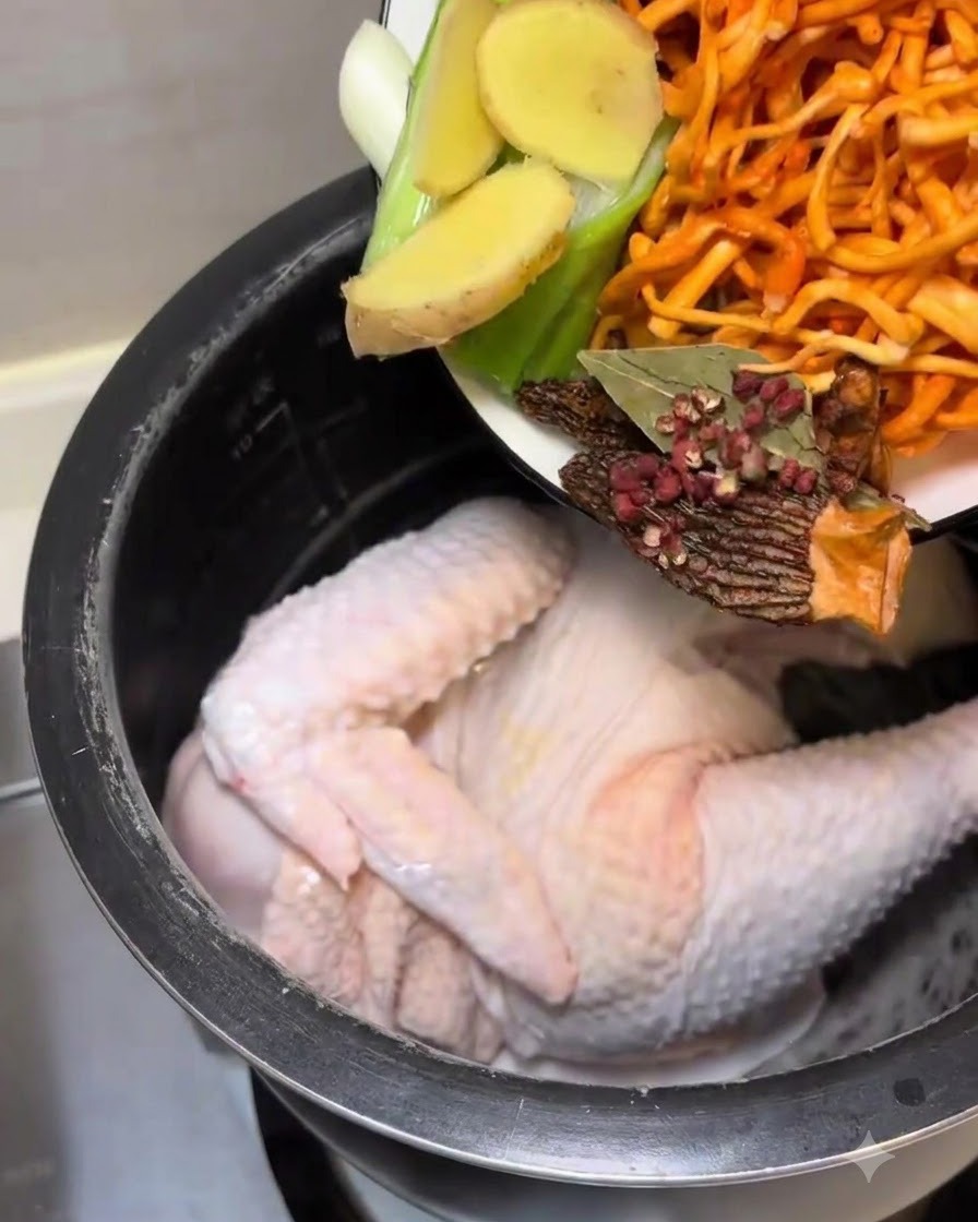 Geben Sie die vorbereiteten Aromaten und Pilze in den Kochertopf mit dem Hähnchen.