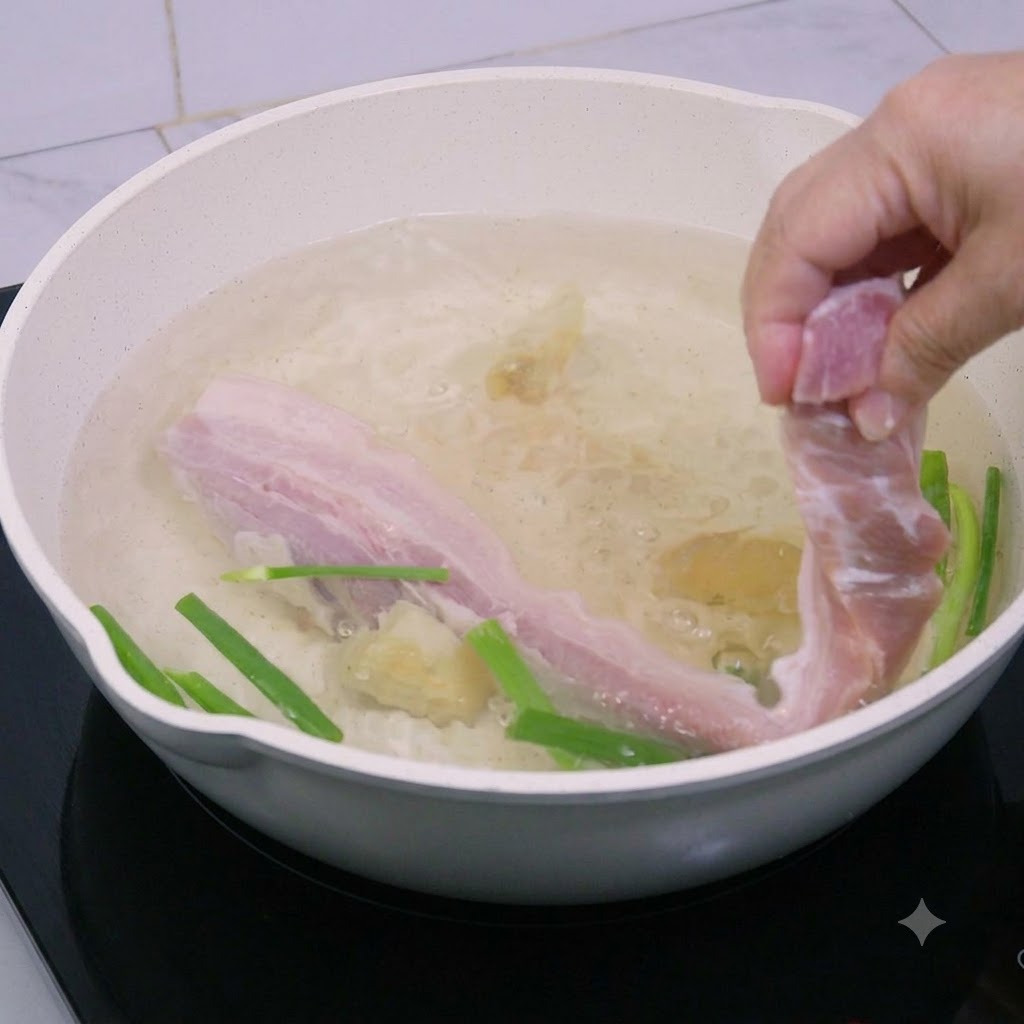 Schweinebauchstreifen werden in einen Topf mit kochendem Wasser abgesenkt.