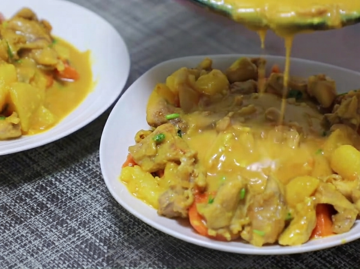 Kartoffel- und Karottenstücke werden in die Pfanne gegeben und mit der Curry-Basis angebraten.