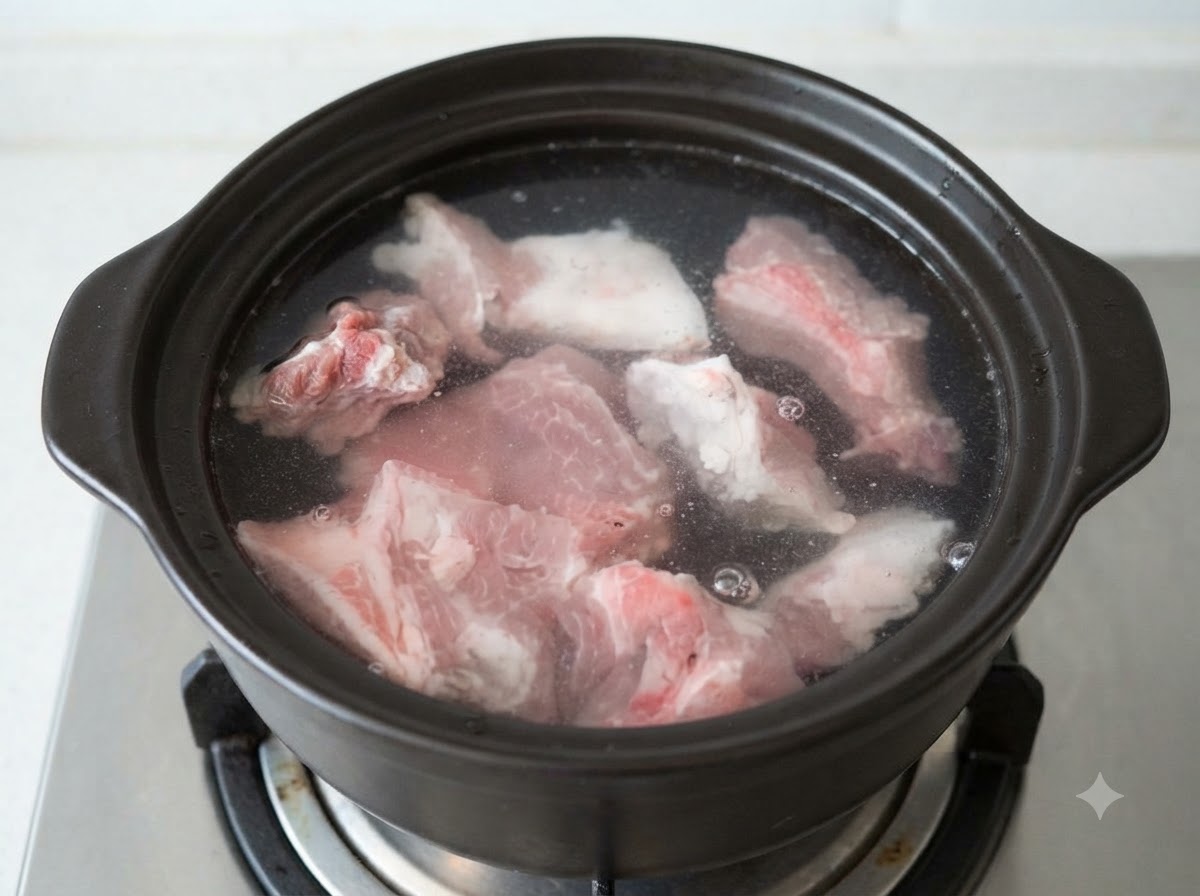 Rohe Schweineknochenstücke eingetaucht in kaltes Wasser in einem dunklen Tontopfcite: 1.