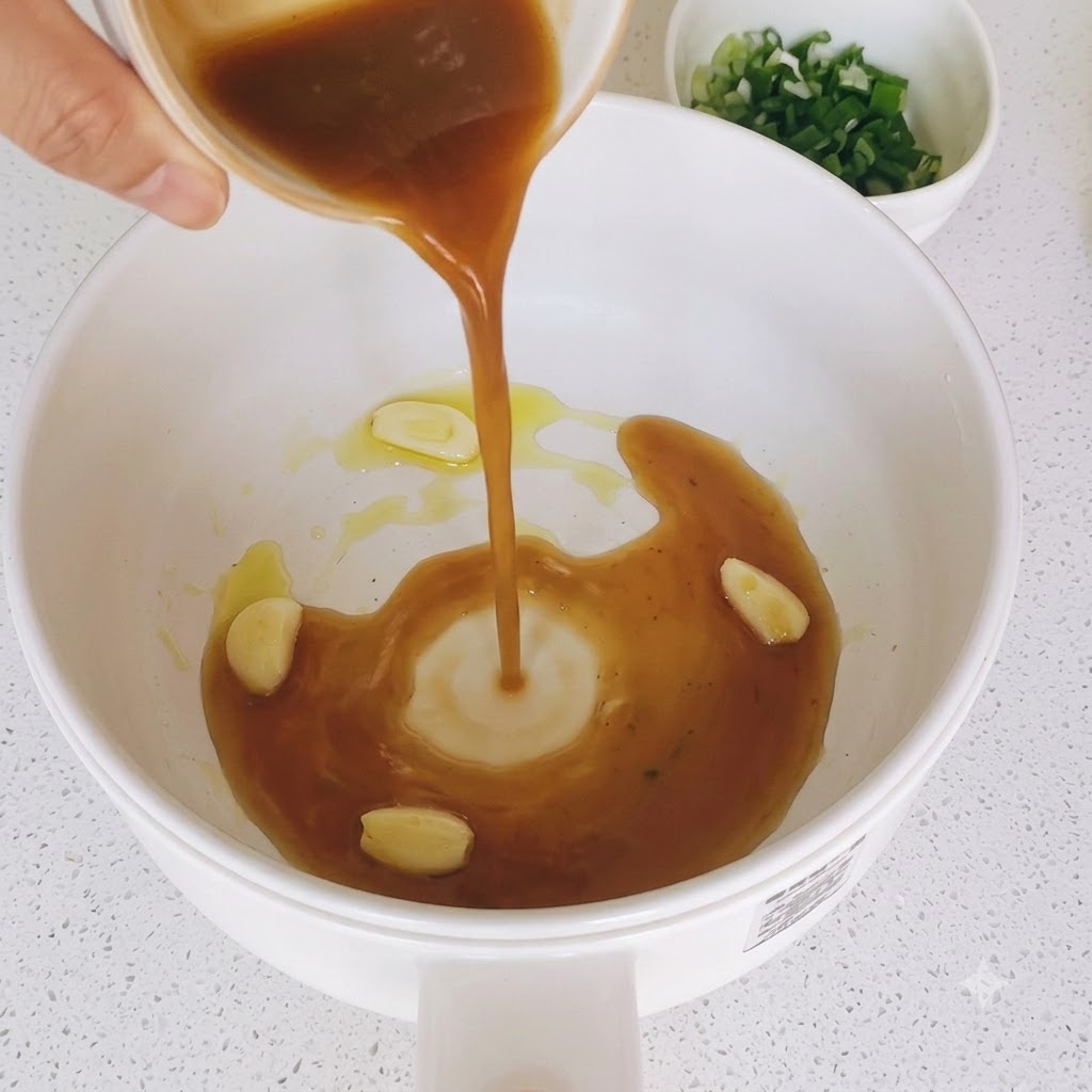 Braune Saucenmischung wird in eine Pfanne mit angebratenen Knoblauchscheiben gegossen.