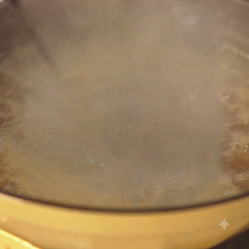 Spaghetti kochen kräftig in einem gelben Topf mit Wasser und aufsteigendem Dampf.
