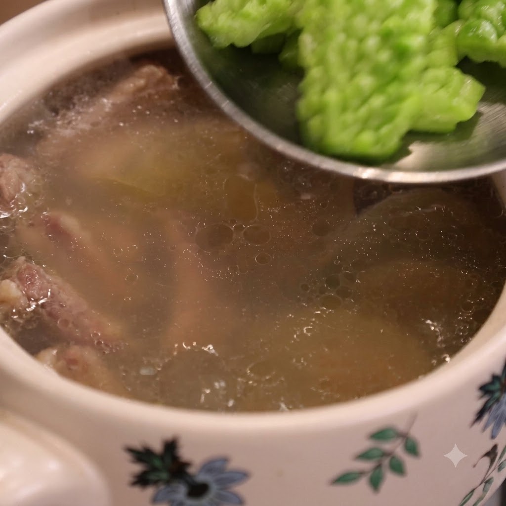 Grüne Bittermelonenscheiben werden mit einem Löffel in einen Topf mit köchelnder Suppe gegeben.