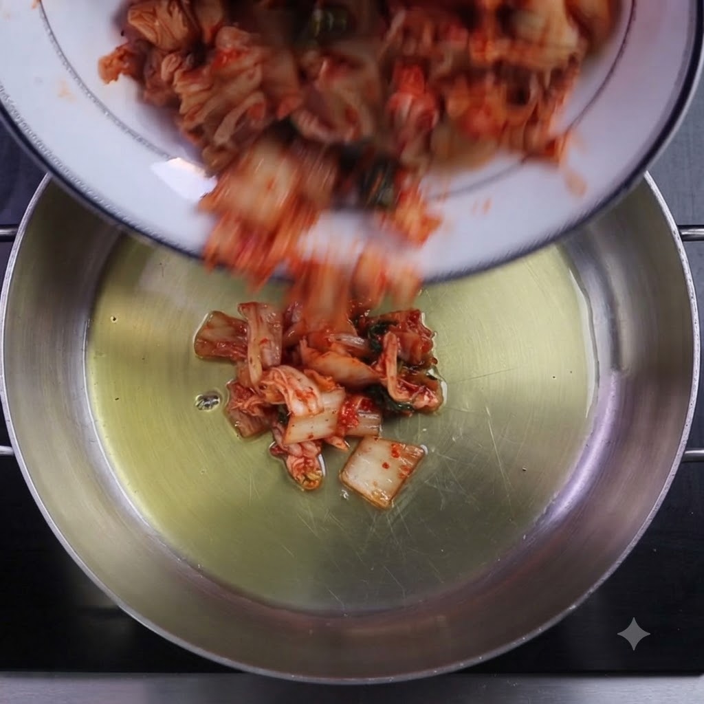 Gehackter Kimchi und Chilipulver werden in einen geölten Kochtopf gegeben.