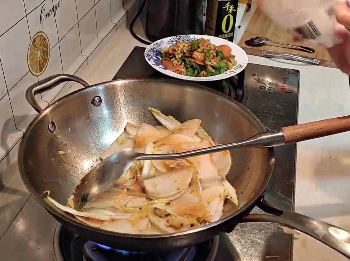 Salz wird aus einer Verpackung in einen Wok mit geschnittenem Gemüse gestreut.