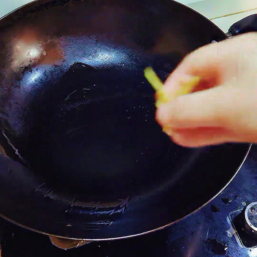 Ingwer und Knoblauchstücke werden in einen Wok mit geschmolzenem Schmalz über Hitze gegeben.