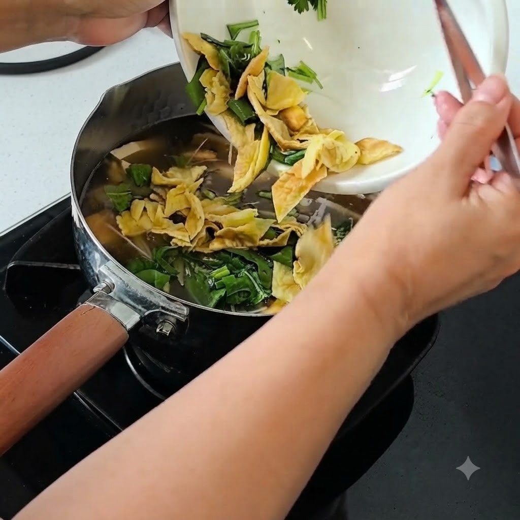 Frühlingszwiebeln, Koriander und gehacktes Jahrhundert-Ei werden aus einer Schüssel in die Suppe gegeben.
