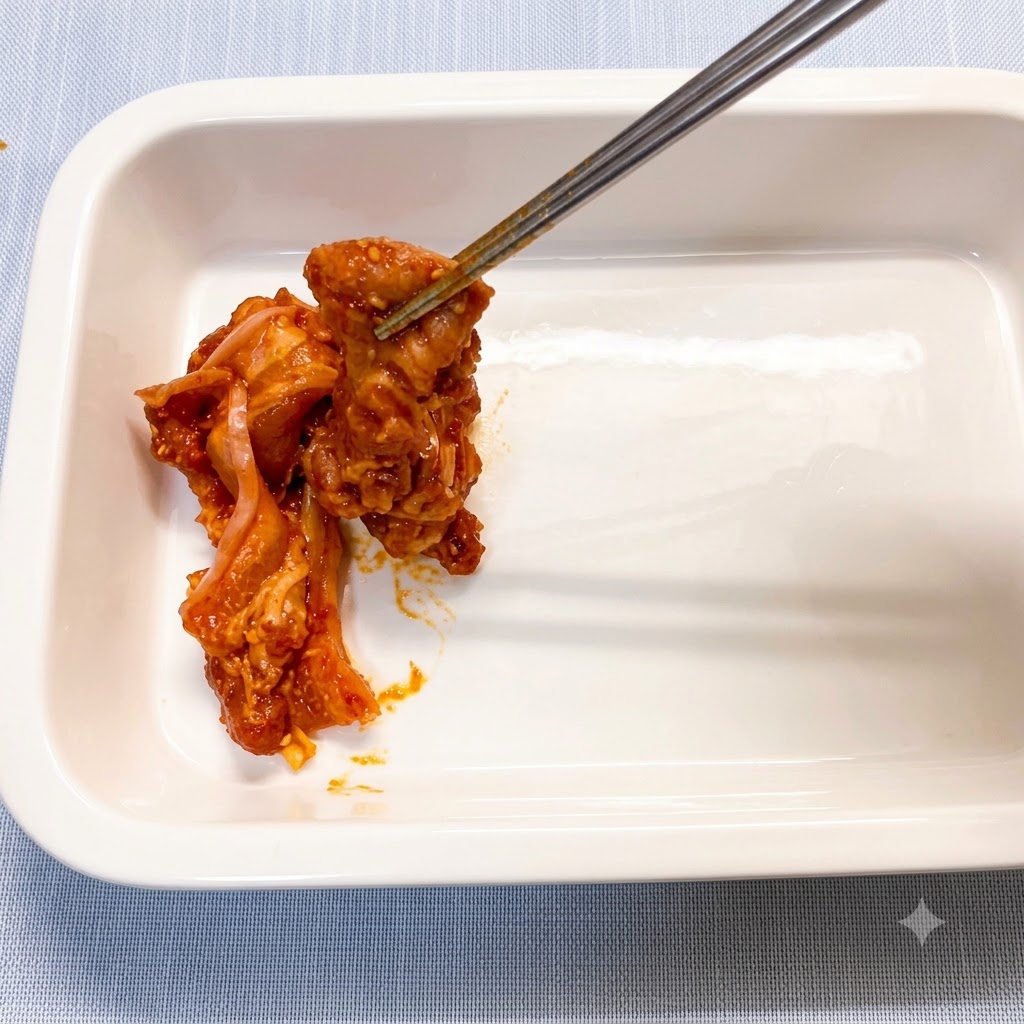 Marinierte Schweinebauchscheiben werden einzeln mit Stäbchen in eine saubere, weiße Keramikauflaufform gelegt.