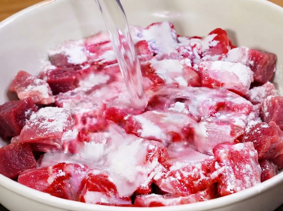 Sauberes Wasser wird in die Schüssel mit den Schweinerippchen gegossen.