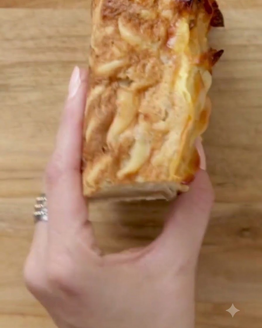 Eine Hand hält ein sauber geschnittenes Kugelquadrat auf einem Holzbrett.