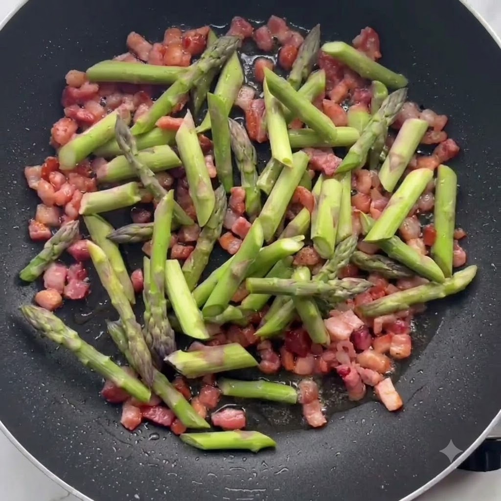 Grüne Spargelstücke braten zusammen mit knusprigem Speck in einer Bratpfanne an.