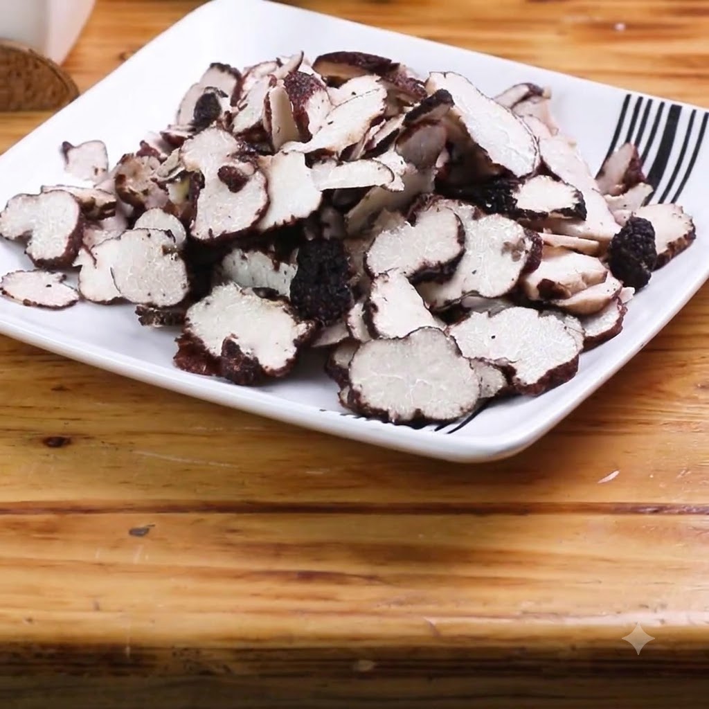Dünn geschnittene Knoblauchzehen sind auf einem Holzschneidebrett angeordnet.