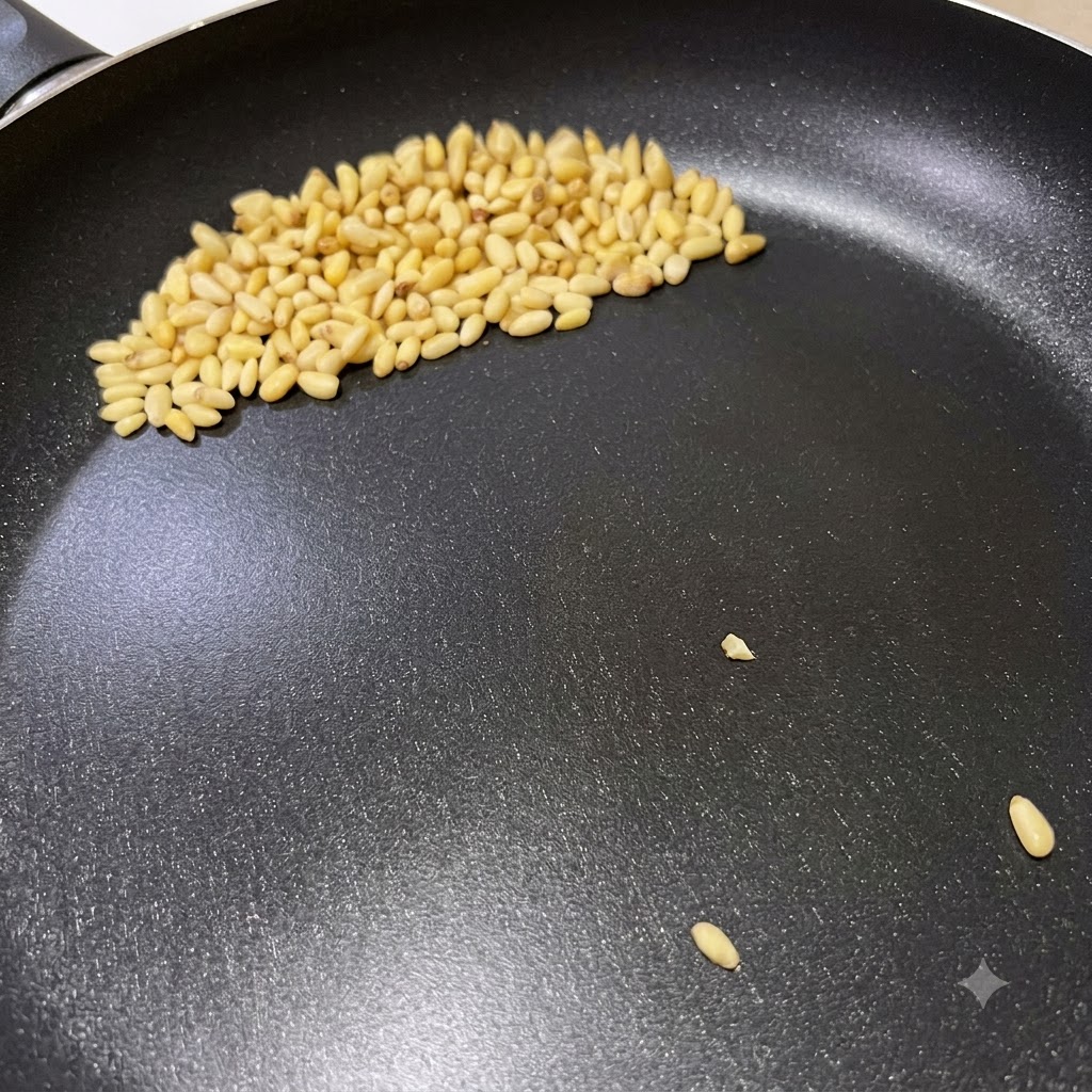 Pinienkerne bräunen in einer trockenen Bratpfanne während der Vorbereitung für die Pesto-Pasta.