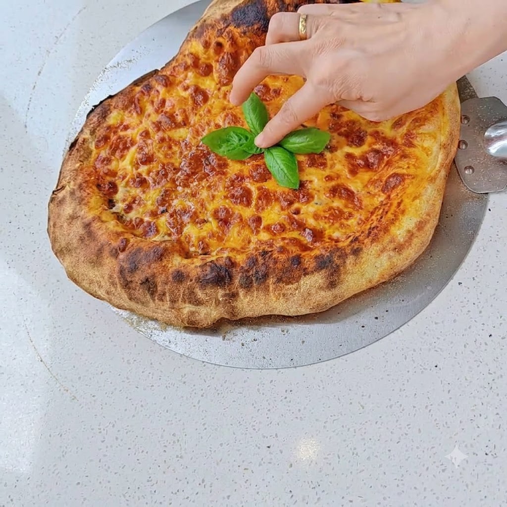 Salamischeiben werden auf die Käseschicht einer vorbereiteten Pizza gelegt.
