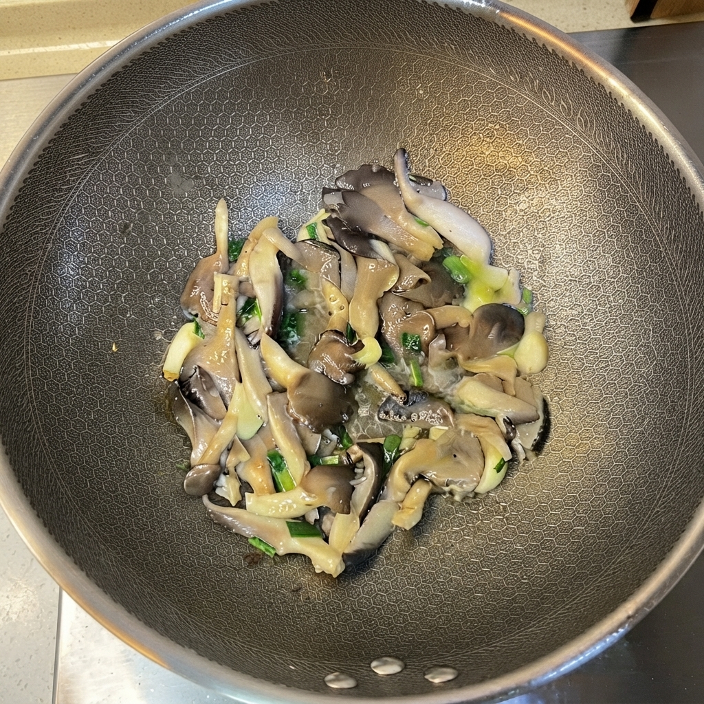 Gegarte Austernpilze und Aromaten werden im Wok vermischt.