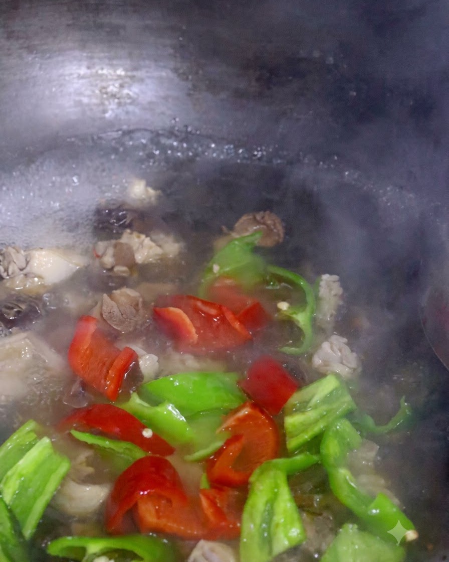 Rote und grüne Paprikastreifen und Pak Choi kochen zusammen mit Pilzen in einem Topf.