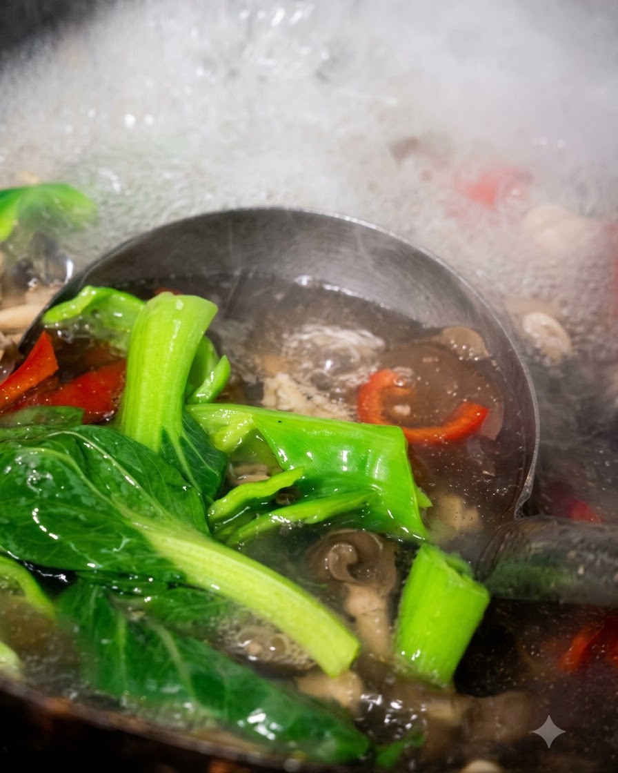 Eine Schöpfkelle holt gekochten Pak Choi, Paprika und Pilze aus dem kochenden Wasser.