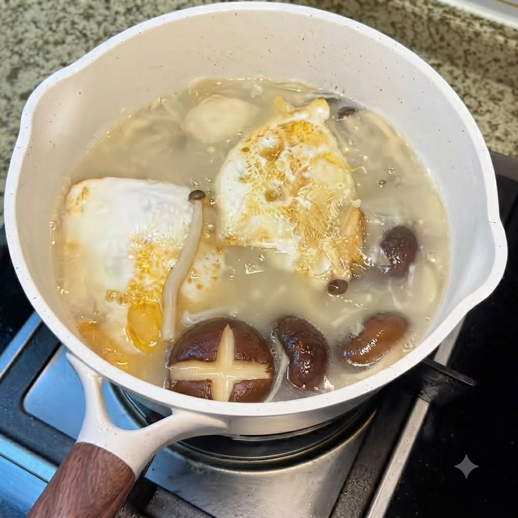 Gemahlener weißer Pfeffer rieselt aus einem Streuer in den köchelnden weißen Topf mit Pilzsuppe.