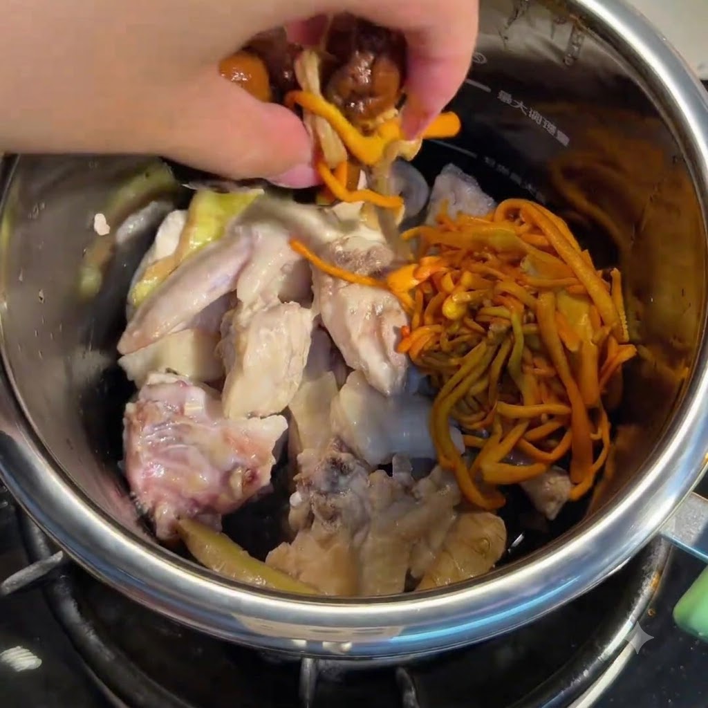 Hand gibt eingeweichte Pilze und Cordyceps-Blüten in den Topf mit Hähnchen.