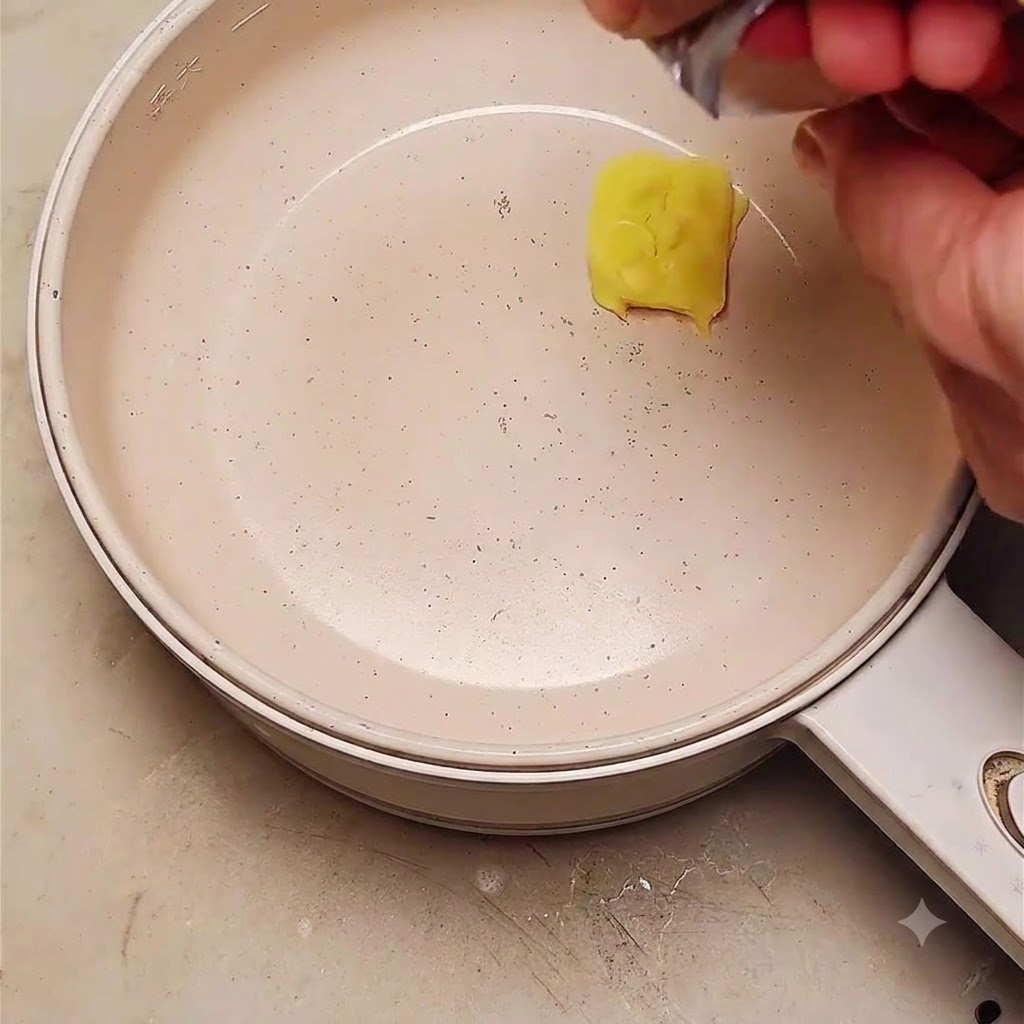 Ein Stück Butter schmilzt in einer Bratpfanne, während geschnittene rote Zwiebeln hinzugefügt werden.