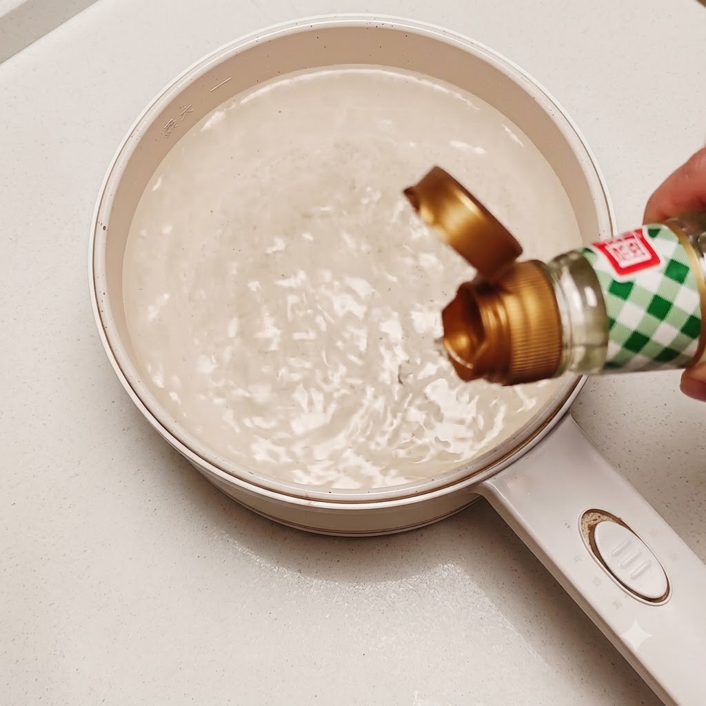 Ein essbares rohes Ei wird in einen Topf mit wirbelndem heißem Wasser und etwas Reisessig gegeben.
