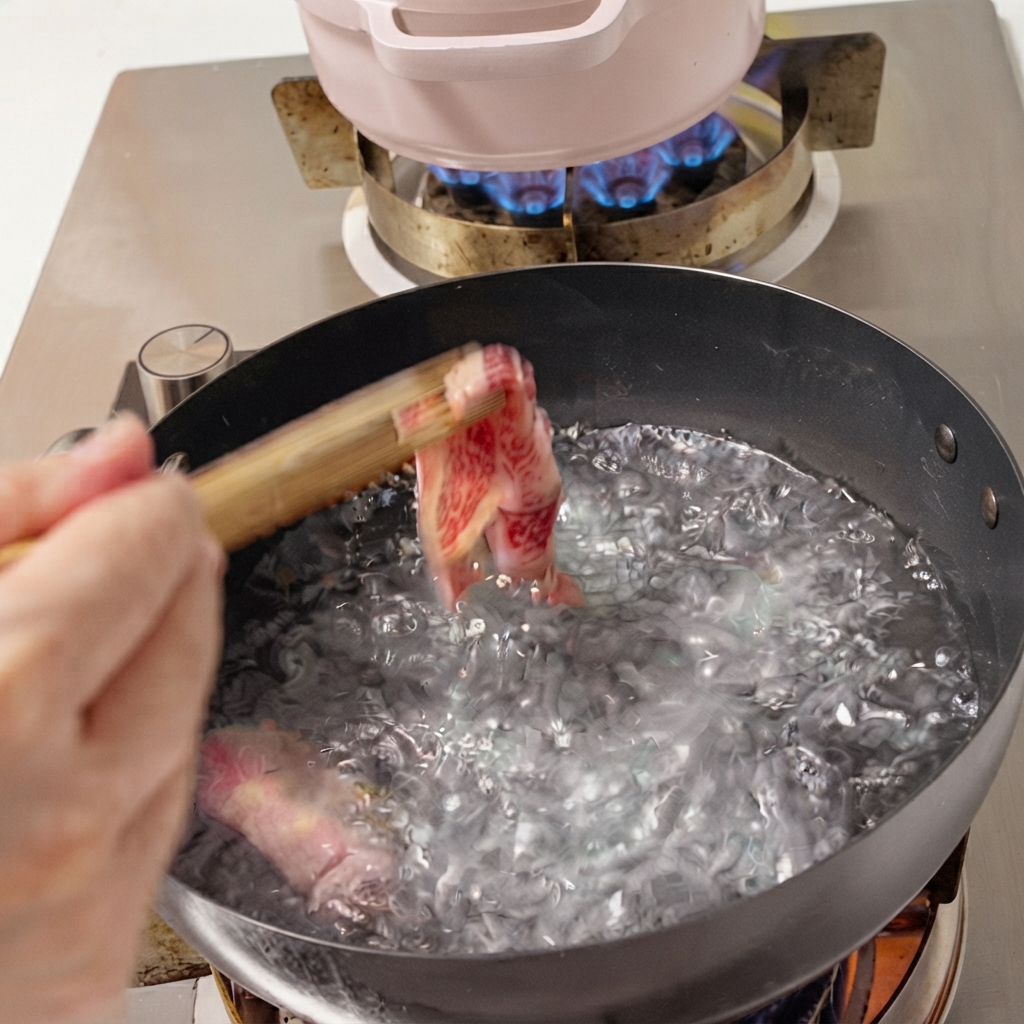 Frische Rindfleischscheiben werden mit Stäbchen in einen Topf mit kochendem Wasser gegeben.
