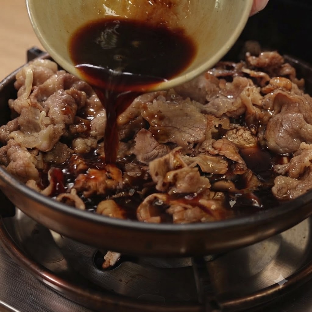 Dunkle Teriyaki-Soße wird aus einer kleinen Schüssel in eine Pfanne mit geschnittenem Rindfleisch und roten Zwiebeln gegossen.