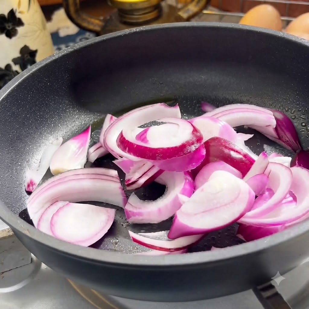 Rote Zwiebeln und Rindfleischstreifen garen in einer Bratpfanne.