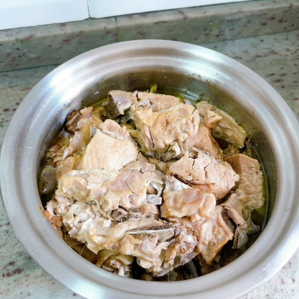 Der Deckel des Schnellkochtopfs wurde entfernt und zeigt das in reichhaltiger Brühe geschmorte Entenfleisch.