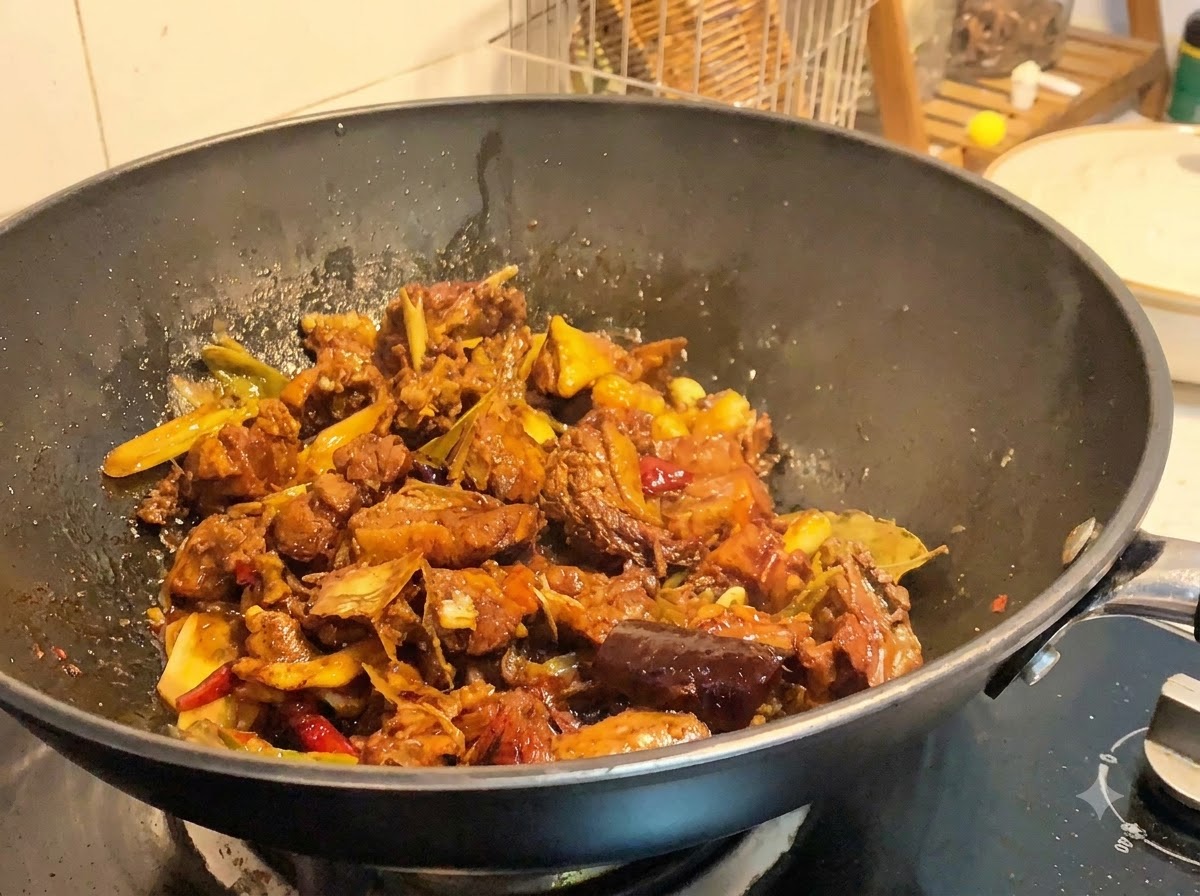 Geschmorte Entenstücke kochen in einem Wok bei starker Hitze, während die Sauce reduziert und eindickt.