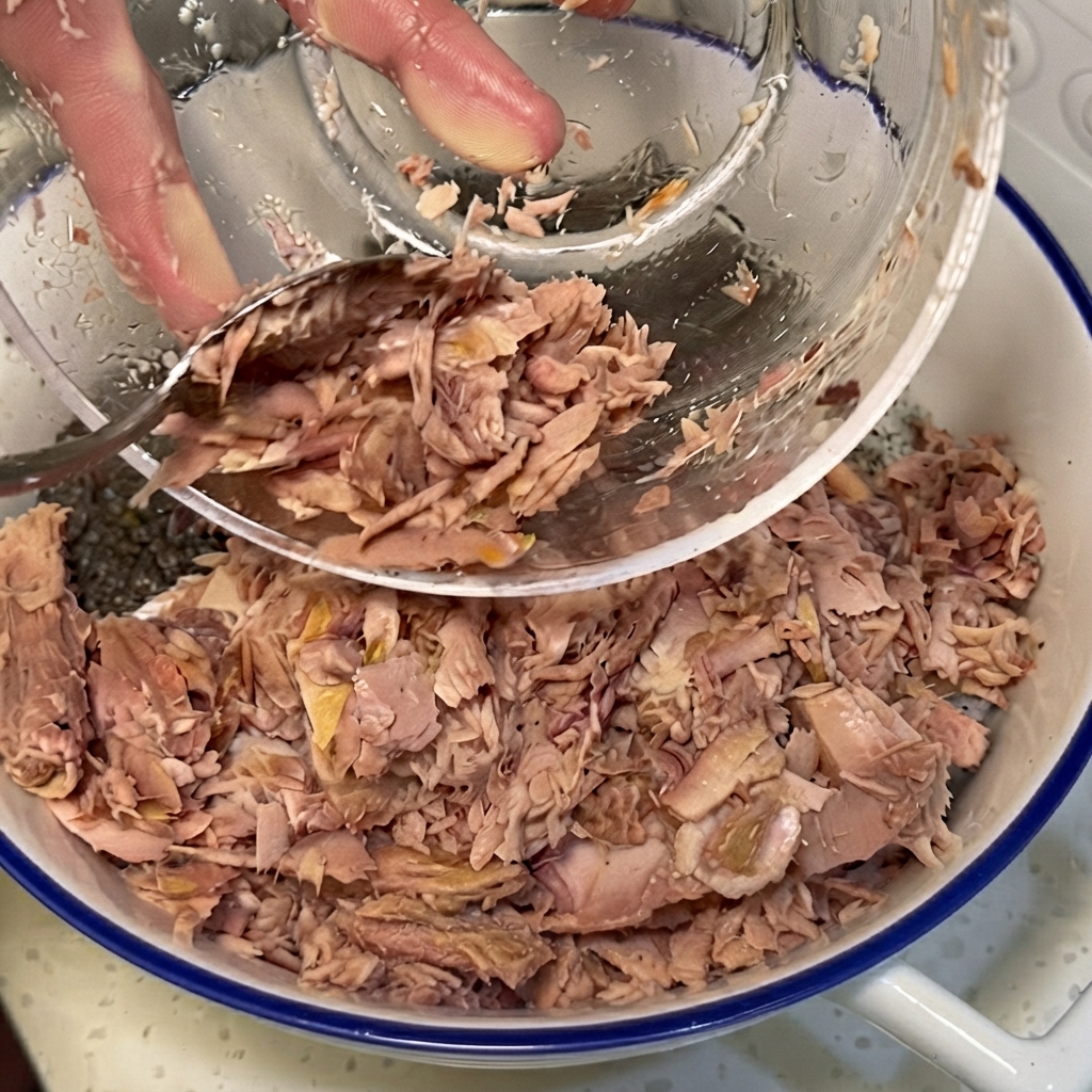 Zerkleinerter Thunfisch, Gemüse und Kohl werden auf dem gewürzten Reis in einer großen Schüssel angeordnet.