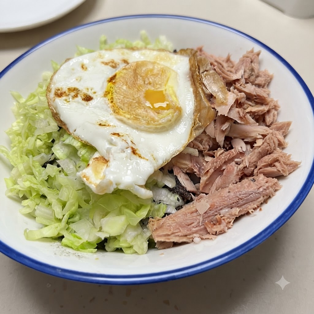 Eine fertige Reisschüssel mit Reis, Thunfisch, Gemüse und einem Spiegelei oben drauf.