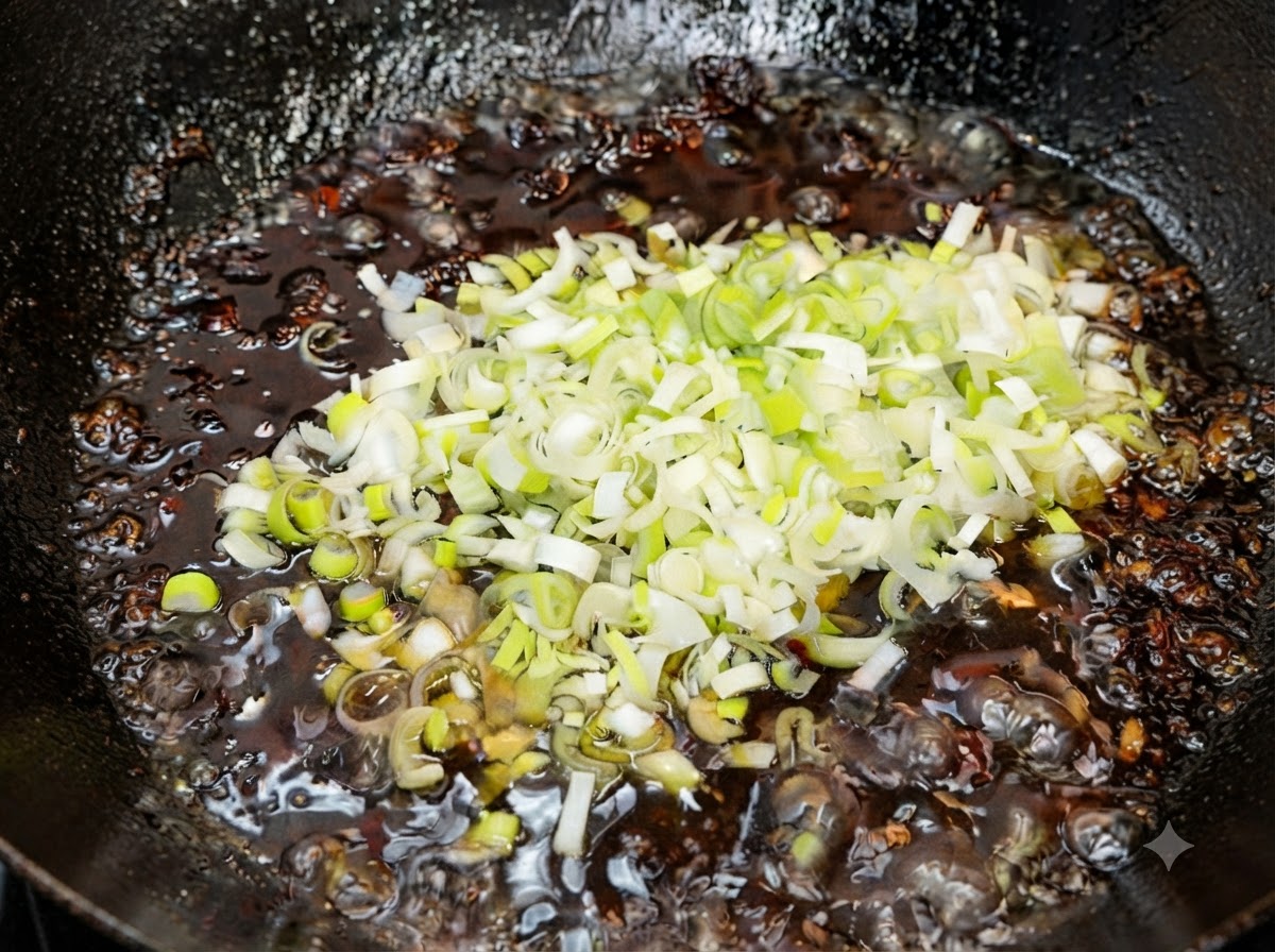 Frisch gehackte grüne Frühlingszwiebeln werden in die heiße fertige Sauce gerührt.