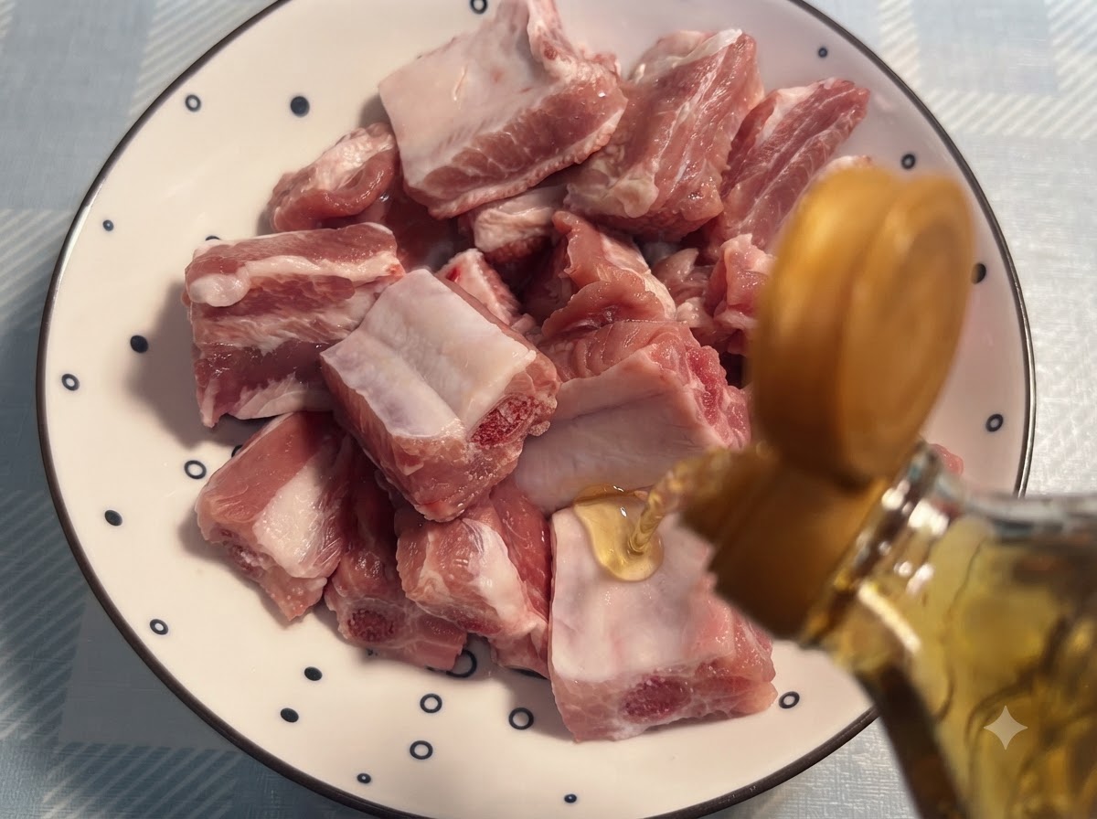 Kochwein wird aus einer Flasche auf rohe Schweinerippchen gegossen, die auf einem gemusterten Teller angeordnet sind.