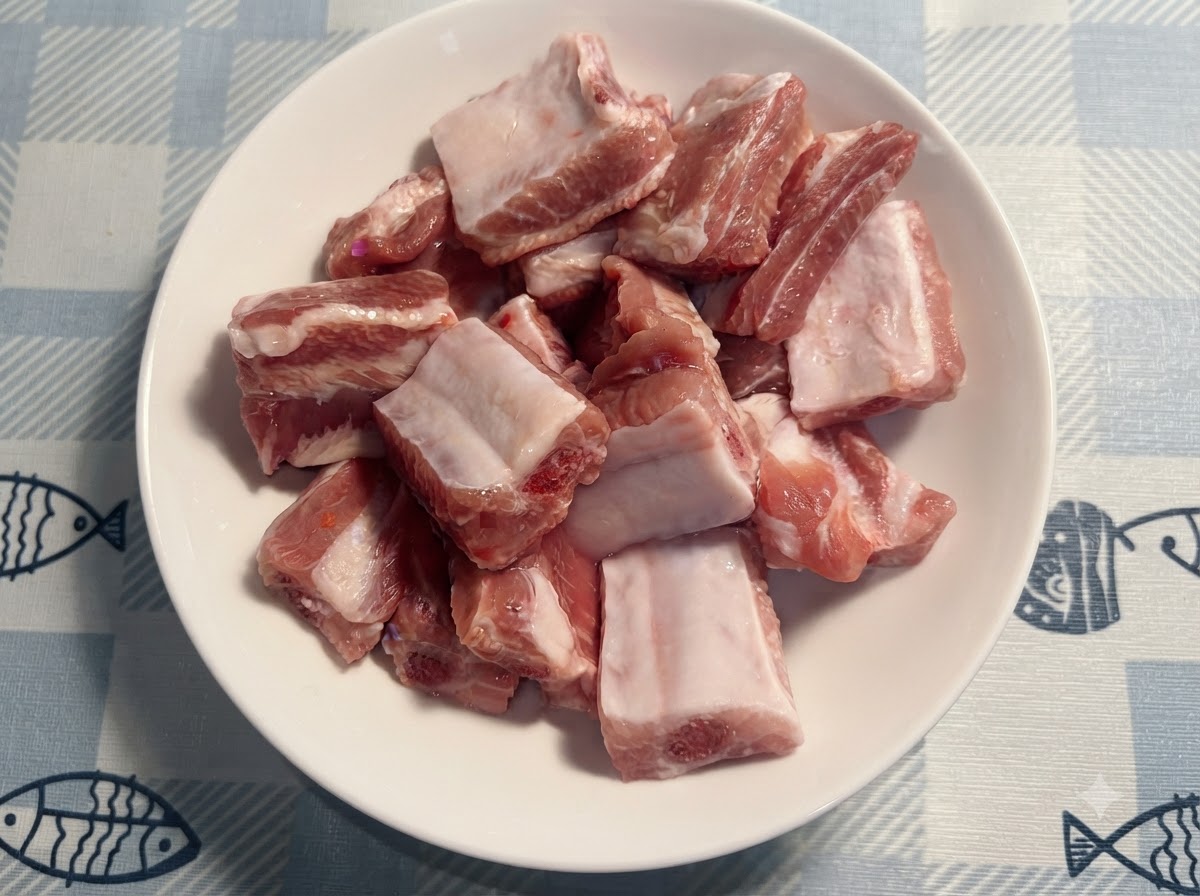 Ein kleiner weißer Löffel fügt Salz zu den rohen Schweinerippchen auf dem Teller hinzu.