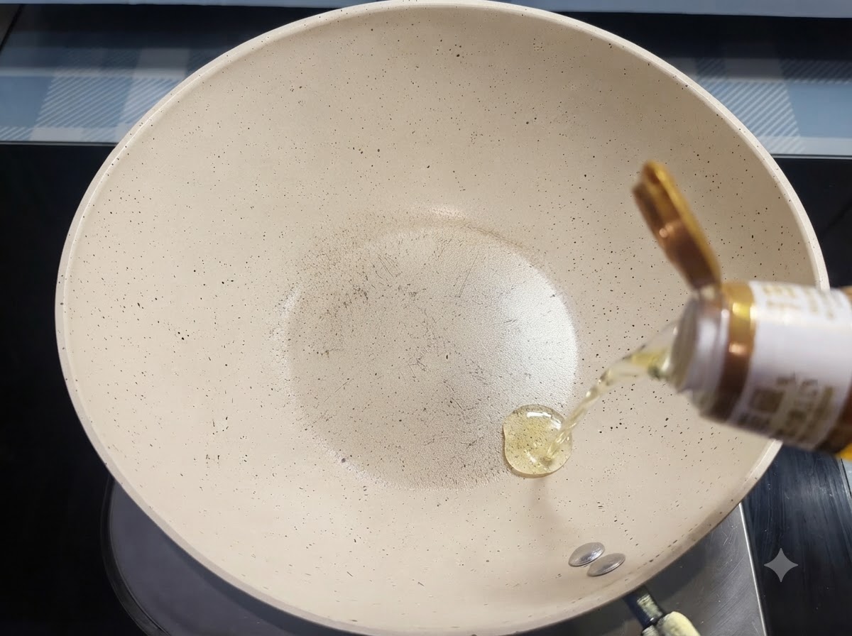 Speiseöl fließt aus einer Flasche in eine weiße Keramik-Bratpfanne.