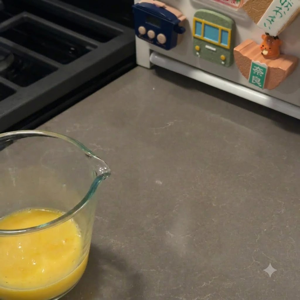 Ein Backpinsel bestreicht vorsichtig die Oberfläche der aufgegangenen Burgerbrötchen mit Eigelb.