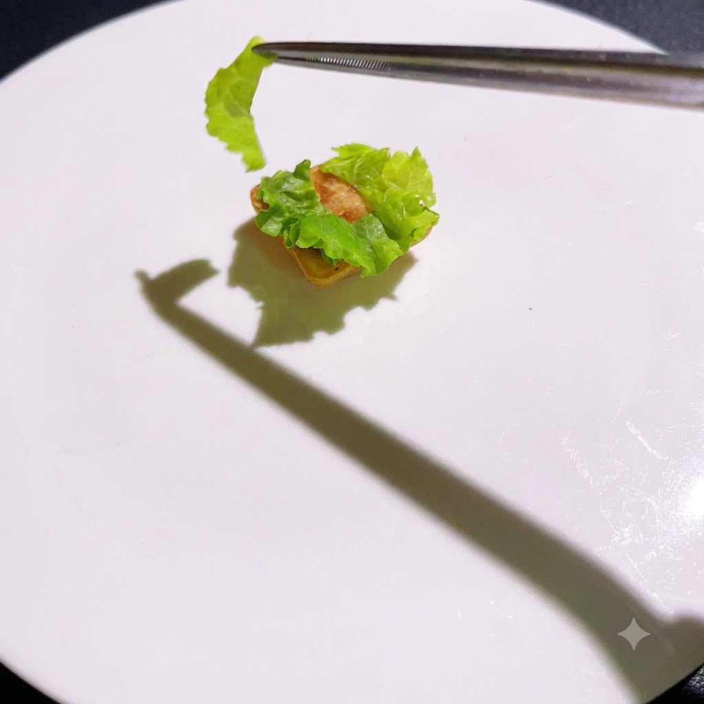 Gekochte Schichten werden nacheinander mit einer Pinzette auf die Salatbasis gestapelt.