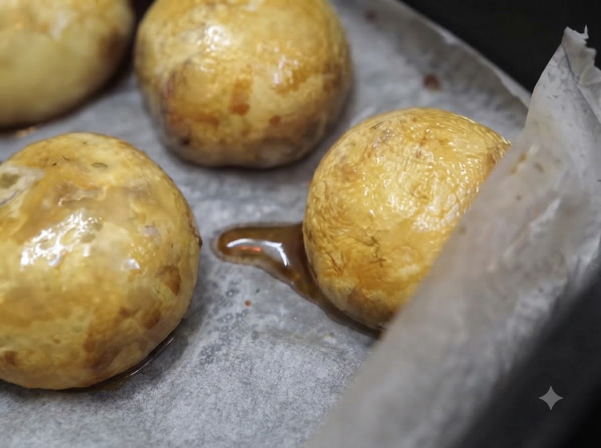 Goldbraun gebackene Pilzköpfe liegen nach dem Heißluftfrittieren auf Backpapier.